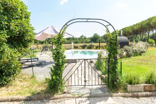 a garden gate with a pool in the background at Villa Donnola: casa Rosmarino in Fucecchio