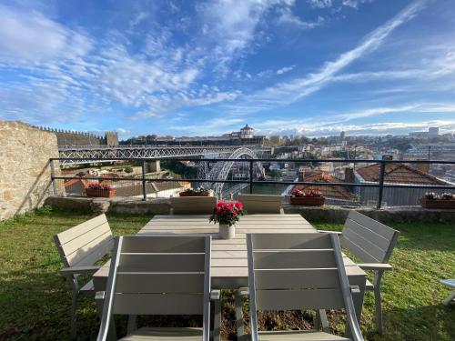 a wooden table with chairs and a view of a bridge at Casa Dona Olga River View in Porto
