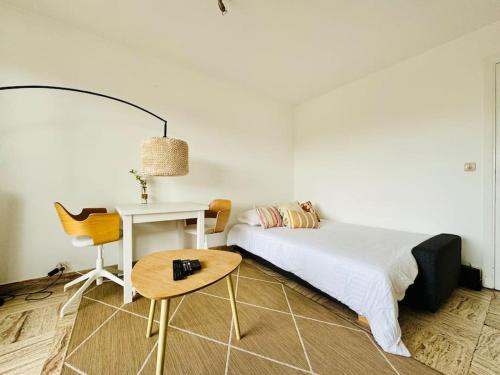 une chambre avec un lit, une table et une chaise dans l'établissement Le Saint Charles, Studio 2 Prs, 300m plages, à Antibes