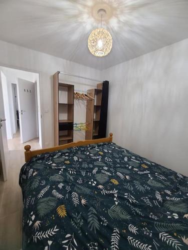 une chambre avec un lit avec une couette verte dans l'établissement Gîte familial proche Annecy et Genève, à Vovray-en-Bornes