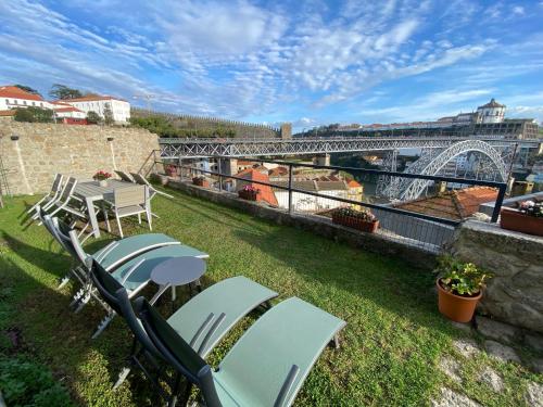 a balcony with chairs and a table and a bridge at Casa Dona Olga River View in Porto