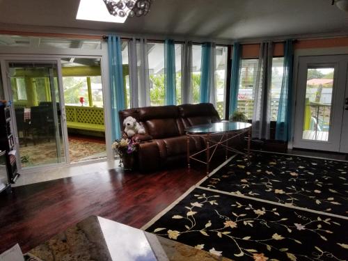 a living room with a leather couch and a table at Fully renovated 4 bd with 2 master suits, 3 bth home in centralized location in Keaau