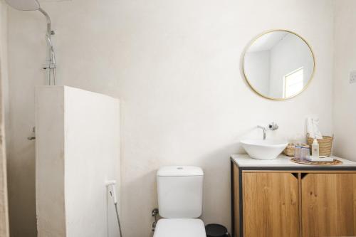 a bathroom with a toilet and a mirror at Zanzibari holiday home by Liv Zanzibar in Paje