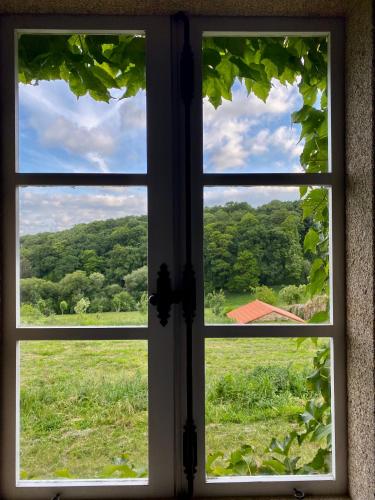 an open window with a view of a field at Hotel Pazo de Bieite in Boimorto