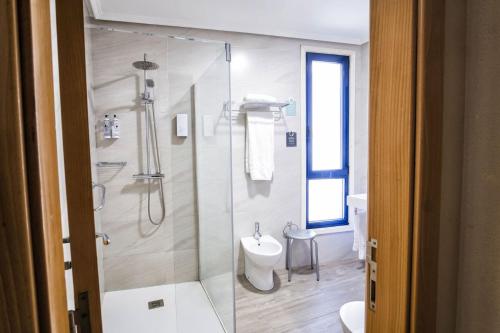 a bathroom with a shower and a toilet and a sink at Hotel Alda Castelao in Vilagarcia de Arousa