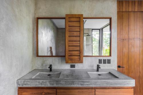a bathroom with two sinks and a mirror at Luxury 4BR Eco Villa 10ppl Outdoor Pizza Oven - Private Pool & Jacuzzi in Tulum