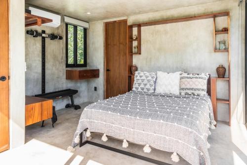 a bedroom with a bed and a desk and a window at Luxury 4BR Eco Villa 10ppl Outdoor Pizza Oven - Private Pool & Jacuzzi in Tulum