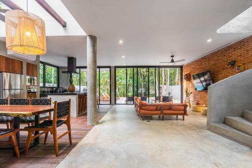 a kitchen and living room with a table and chairs at Luxury 4BR Eco Villa 10ppl Outdoor Pizza Oven - Private Pool & Jacuzzi in Tulum