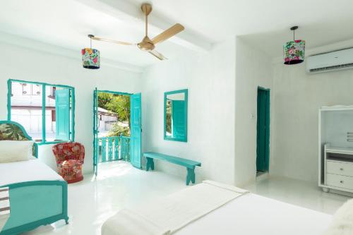 a white room with a bed and a chair at Villa Havana Hues Private Villa in Bentota
