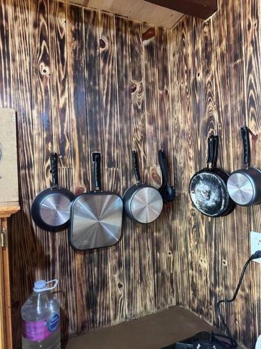 a wall with four pots and pans on it at Cabaña privada en el bosque, cerca al rio Starlinkk in San Mateo Río Hondo