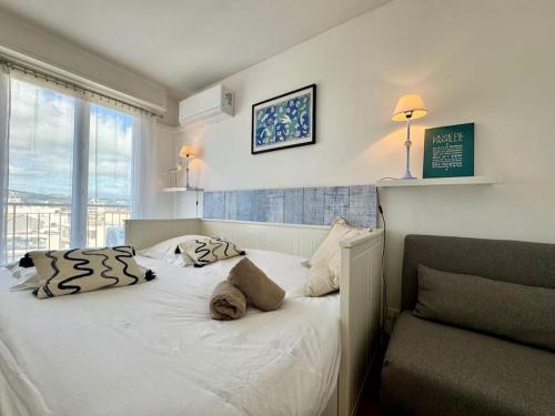 une chambre avec un lit blanc avec une fenêtre dans l'établissement Le Pam'S, Apt de Standing pour 4 prs, Terrasse et Parking, à Antibes