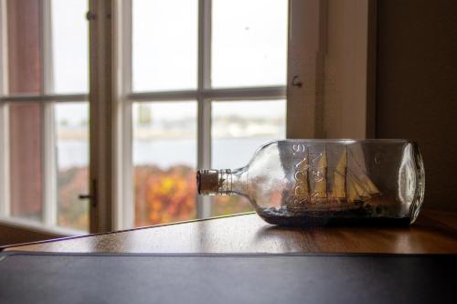 a glass bottle sitting on a table next to a window at Haus zum Schiff in Ermatingen