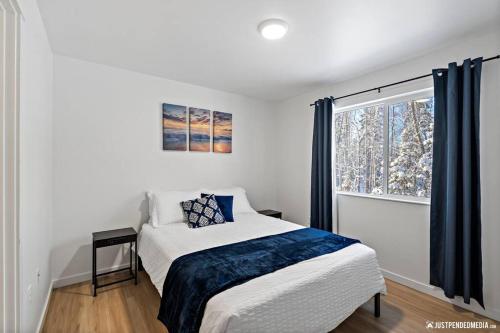 a white bedroom with a bed and a window at Cozy Eagle River Retreat in Eagle River