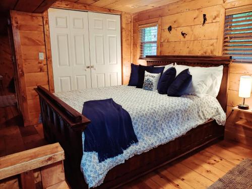 a bedroom with a bed in a log cabin at Trailseeker Cabin w King Bed Hot Tub at Red River Gorge Natural Bridge in Stanton
