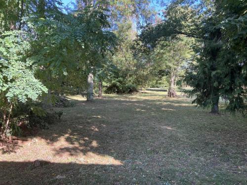 a park with trees and a field of grass at La Petite Trolière in Orval