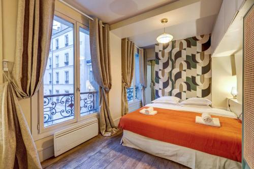 une chambre avec un lit et une grande fenêtre dans l'établissement Le Marais - Les Halles Colorful & Modern 3BD, à Paris