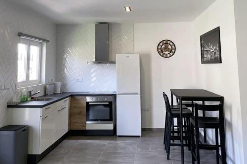 a kitchen with a white refrigerator and a table at Modern Appartement Noord Jan Thiel #2 in Willemstad