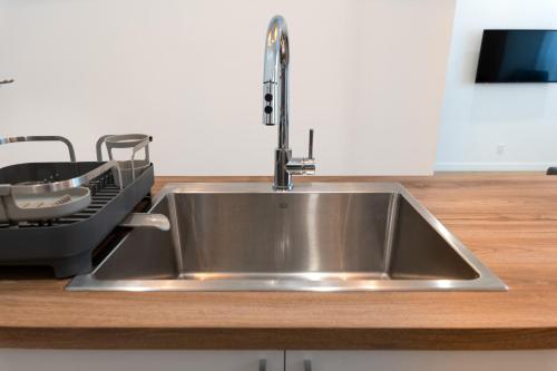 - un évier en acier inoxydable dans la cuisine équipée d'un lave-vaisselle dans l'établissement #1 - Luxurious 2Bds - Self Check in - Plateau - St-Denis - AC - TV, à Montréal