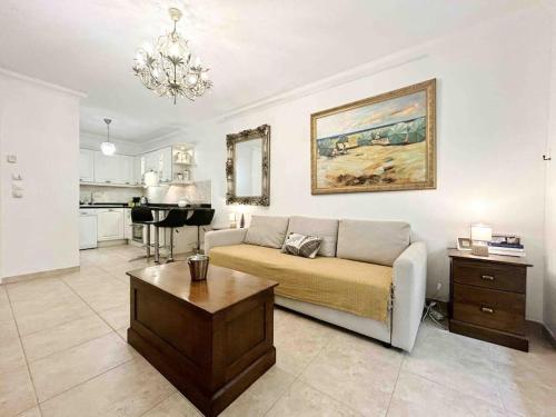 un salon avec un canapé et une table dans l'établissement Le Square Pauline, Apt 4 Prs, Jardin, 300m Mer, à Antibes