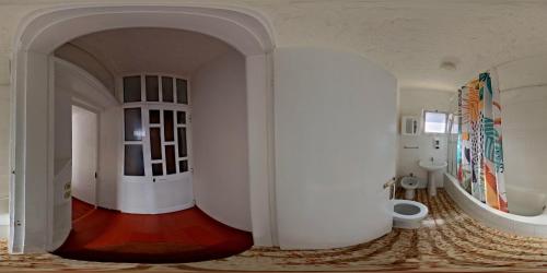 a white hallway with a toilet in a room at Pensão Fernandes in Porto Moniz