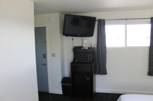 a bedroom with a flat screen tv on a wall at Sprague Motel in Sprague