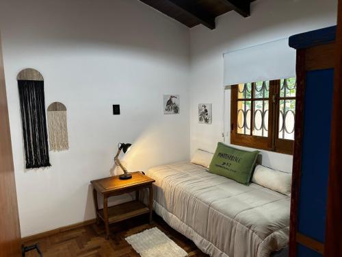 a bed in a room with a table and a window at Rincón de Arístides in Mendoza