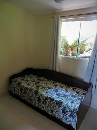 a bed sitting in a room with a window at Pousada Ecomar in Florianópolis