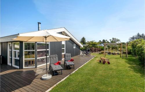 a deck with an umbrella and chairs and a playground at Lovely Home In Hjørring With Wifi in Hjørring
