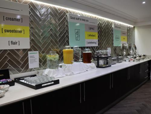 a buffet line with glasses of orange juice and drinks at Garner Hotel Preston Samlesbury by IHG in Preston