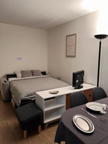 une chambre avec un lit et un bureau avec un ordinateur dans l'établissement T2 parking privé proche centre ville et gare, à Voiron