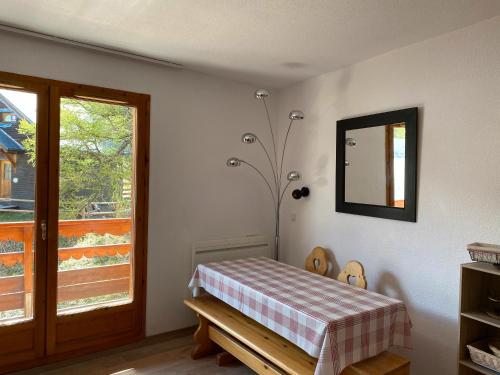 リスルにあるAppartement Risoul 1850のテーブル、鏡、窓が備わる客室です。