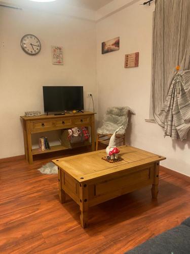 a living room with a coffee table and a tv at Appartamento Sorapiss in Lorenzago