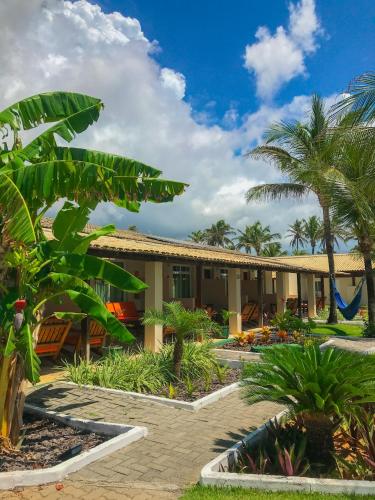 un complejo con palmeras y un edificio en Sunset Beach Taíba Hotel, en Taíba