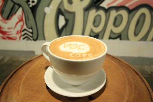 a cup of coffee sitting on top of a table at The Kresna Hotel in Yogyakarta