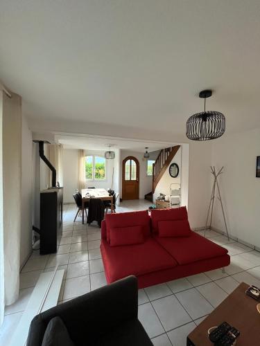 un salon avec un canapé rouge et une table dans l'établissement Maison de la Croix Blanche, à Colmar