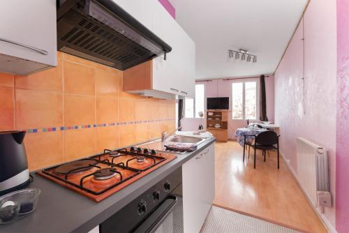 Il comprend une cuisine équipée d'une cuisinière. four supérieur à côté d'un comptoir dans l'établissement Studio Centre Saint-Girons, à Saint-Girons