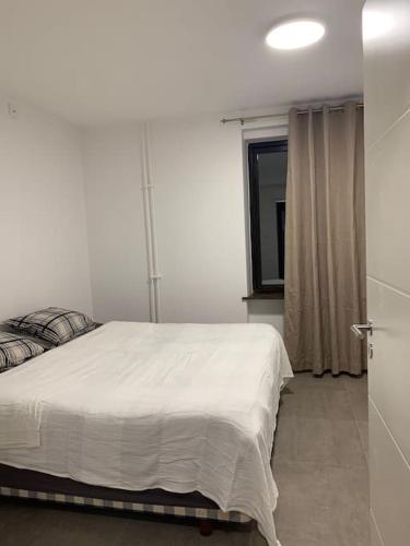 a bedroom with a white bed and a window at Mysig lägenhet Malmö Centralt in Malmö