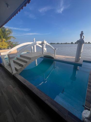 a pool with a wooden bridge over a body of water at Hotel River Blue in Tlacotalpan