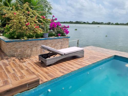 a bench on a wooden deck next to a swimming pool at Hotel River Blue in Tlacotalpan