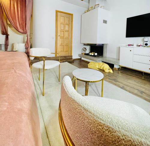 a living room with a couch and chairs and a tv at IN ROOM Old town Kaunas in Kaunas