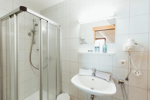 a white bathroom with a sink and a shower at Apart Himmel-Raich in Kaunertal