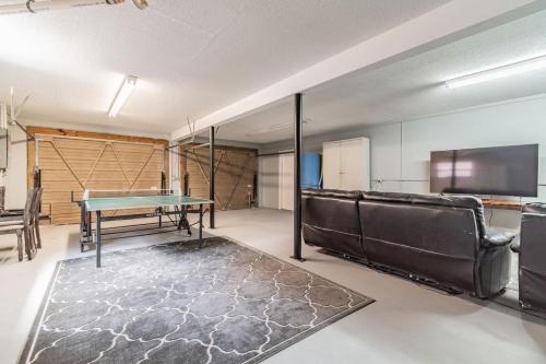 a room with a ping pong table and a couch at Landing at Richard Weeki River in Spring Hill