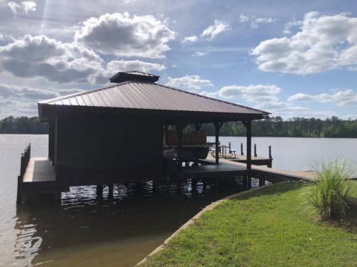 a gazebo on a dock on a lake at Ultimate Family Fun Lakehouse with pool and dock in Eatonton