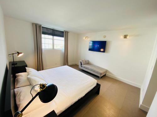 ein Schlafzimmer mit einem Bett mit einer Lampe und einem Stuhl in der Unterkunft Luxurious and Centrally-located 1BR Condo by the beach! in Sunny Isles Beach