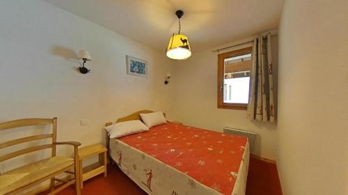 une petite chambre avec un lit et une chaise dans l'établissement Résidence Terrasses De La Bergerie - 2 pièces 4 personnes MAE-8344, à Orcières
