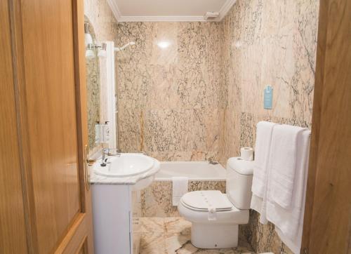 a bathroom with a toilet and a sink at Alda Alpina in Villanueva de Arosa