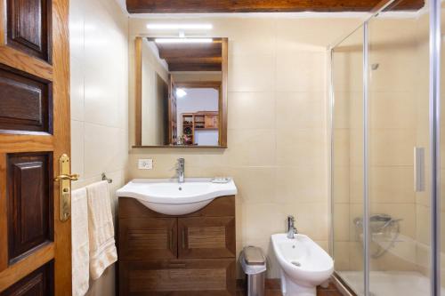 Un baño con lavabo, inodoro y espejo. en Casa Rural Los Barros, en Genovés