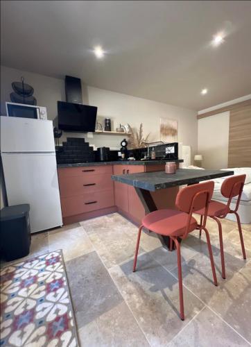 cocina con mesa y silla roja en Studio pied de coline LYVIN, en Ginasservis