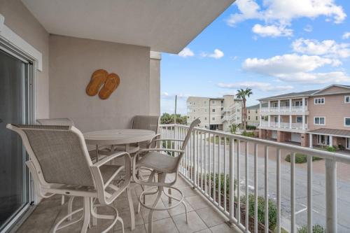 a balcony with a table and chairs and a view at Tybee Turtle Time Condo in Tybee Island