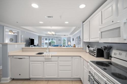 a white kitchen with white cabinets and appliances at Tybee Turtle Time Condo in Tybee Island